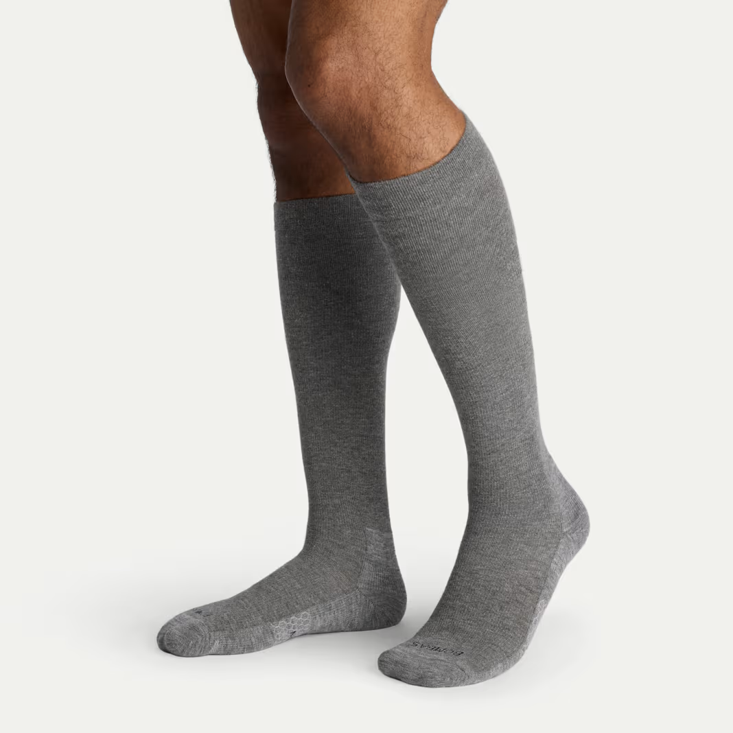 Two legs in grey knee-high compression socks, standing